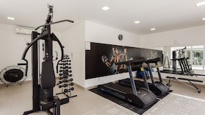 Een moderne sportschool met loopbanden, krachttoestellen en een grote spiegel.
