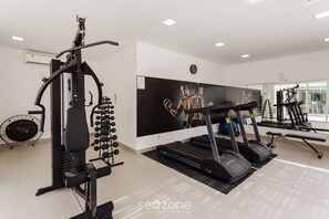 A modern gym with treadmills, weight machines, and a large mirror. - New apt With Barbecue 350m From the Beach Rtg101 (Florianópolis)