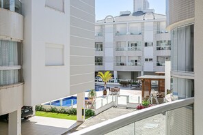 A modern building with multiple balconies, a pool area, and outdoor seating. - New apt With Barbecue 350m From the Beach Rtg101 (Florianópolis)