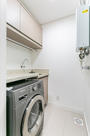 A compact laundry room with a Samsung washing machine, a sink, and a water heater. - New apt With Barbecue 350m From the Beach Rtg101 (Florianópolis)