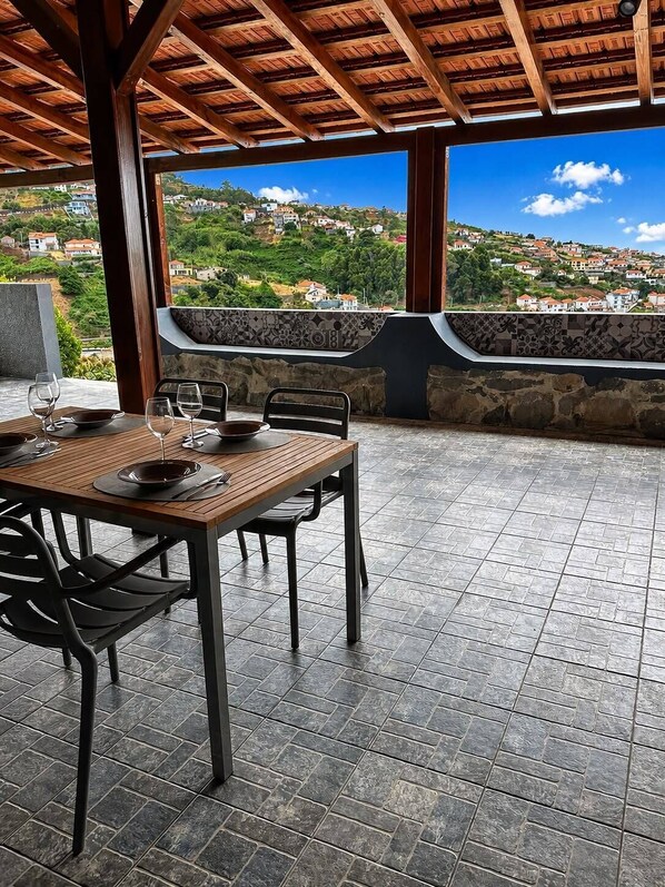 An outdoor dining area with a view of a hillside town.