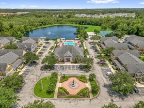 A residential area with a central swimming pool, a fountain, and a landscaped courtyard. - Cozy Kissimmee Getaway Near Orlando Attractions (Kissimmee)