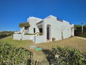 A modern white building with a flat roof, a small entrance, and a clear blue sky. - Albufeira Balaia Golf Vilage 8 by Homing (Albufeira)