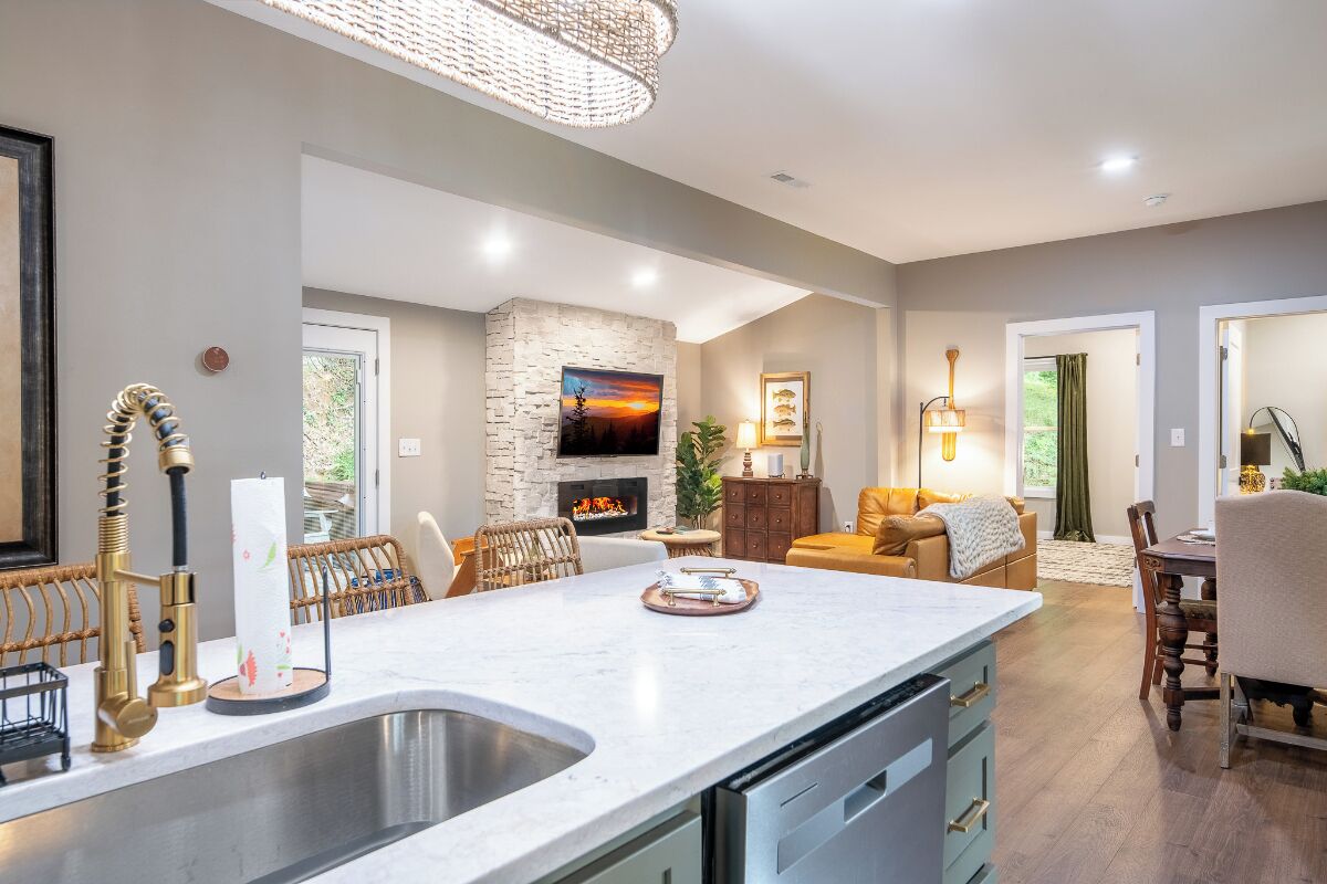 A modern kitchen with a large island, built-in appliances, and a stone accent wall.