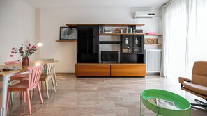 A modern living room with a dining area, a sofa, and a TV stand. - Italianway Comfort - Torre 24 (Milano)