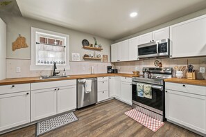 A modern kitchen with white cabinets, stainless steel appliances, and wooden countertops. - Hildy's Hideaway | NEW! Sleeps 10 | Direct Snowmobile Access | Near Saddleback & Downtown (Rangeley)