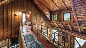 A wooden cabin interior with a staircase, a ceiling fan, and a deer head decoration. - The Boston | Waterfront on Mooselookmegtunic Lake | Pet Friendly (Rangeley)