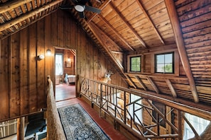 A wooden cabin interior with a staircase, a ceiling fan, and a deer head decoration. - The Boston | Waterfront on Mooselookmegtunic Lake | Pet Friendly (Rangeley)