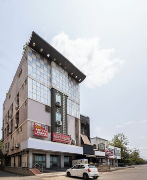 Un hotel de varios pisos con fachada moderna, con amplios ventanales y una entrada destacada con escalones.