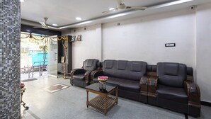 Una sala de estar moderna con un sofá modular, una mesa de centro de madera y un ventilador de techo.