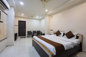Una habitación de hotel con una cama, un escritorio y dos sillas.