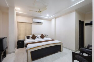 A hotel room with a bed, bedside table, and a ceiling fan.