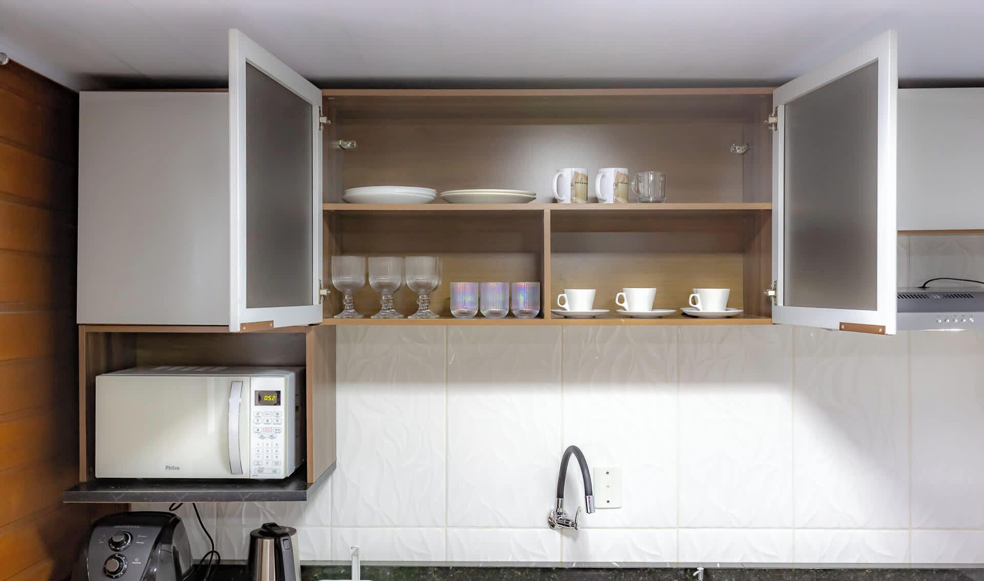A compact kitchen with a microwave, a coffee maker, and a sink.