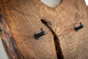 A wooden surface with two black cylindrical objects, possibly fixtures, and a visible crack. - Knöspele Brennerei & Genuss-Apartments Fructum (Brixen)