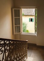 Una escalera con barandilla de metal que lleva a una habitación con ventana.