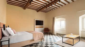 Een hotelkamer met een bed, een stoel, een tafel en een groot raam.