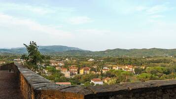 A stone wall overlooking a town with buildings and hills in the distance.