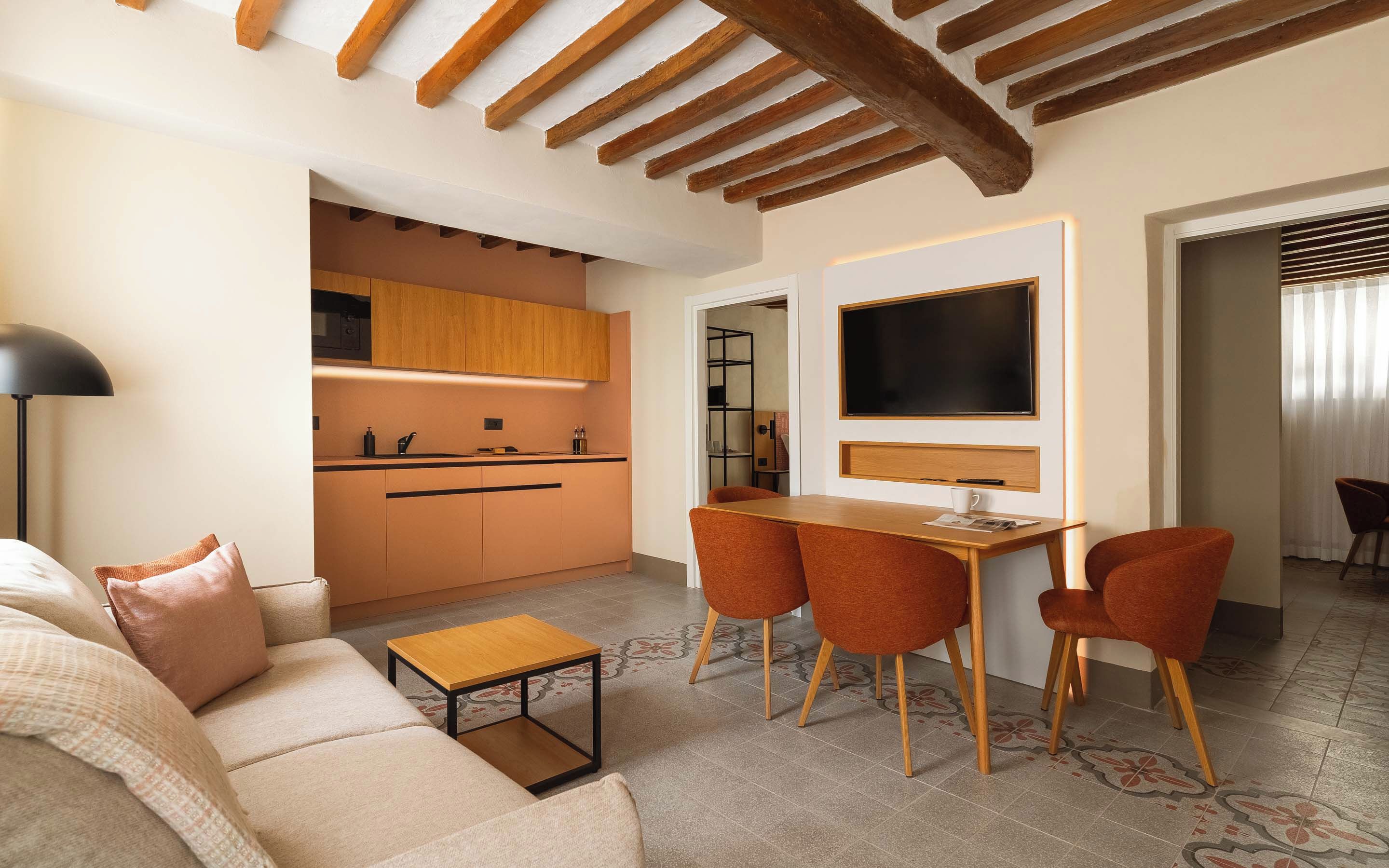 Un salon moderne avec un canapé, une table basse et un téléviseur fixé au mur.