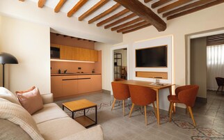 Una sala de estar moderna con un sofá, una mesa de centro y un televisor montado en la pared.