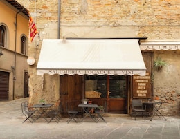 Un restaurante llamado 'SALUMERIA FOCACCE E VINI' con terraza y fachada de piedra.