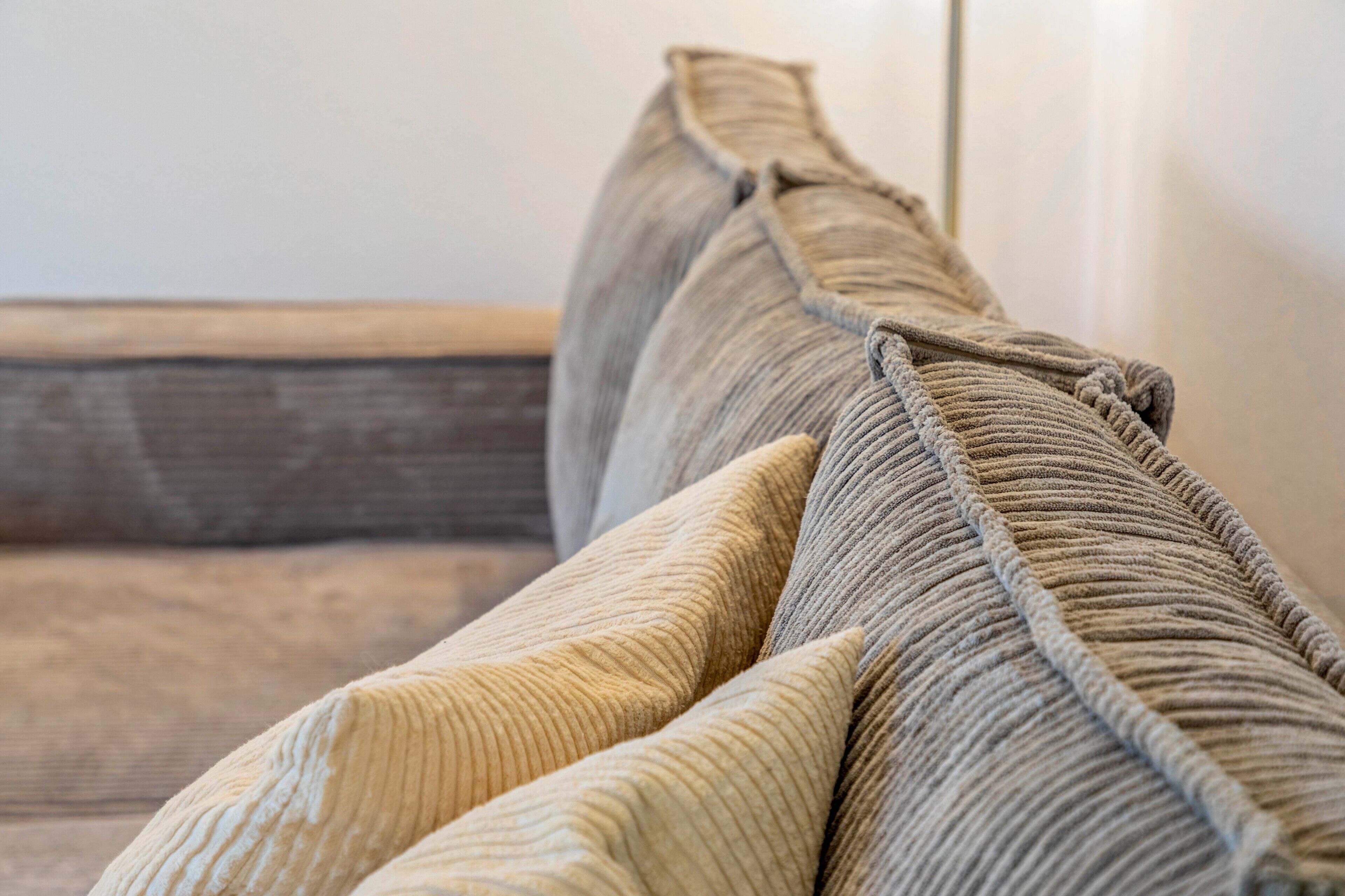 Un gros plan d’un canapé recouvert d’un tissu texturé, dont on peut voir la couture.