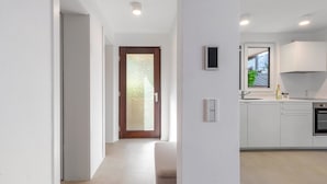 Eine moderne Küche mit Einbauofen, einem Fenster mit Blick und einer Tür zu einem anderen Raum.