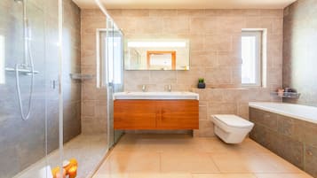 Une salle de bain moderne avec une douche à parois de verre, un meuble-lavabo en bois, des toilettes et une baignoire.