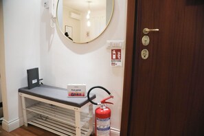 A room with a fire extinguisher, a first aid kit, a telephone, and a mirror on the wall. - A da Sora Valè Boutique Apartment - Vatican & Metro A (Roma)