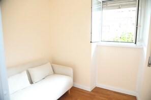 A white sofa against a wall with a window above it. - A da Sora Valè Boutique Apartment - Vatican & Metro A (Roma)