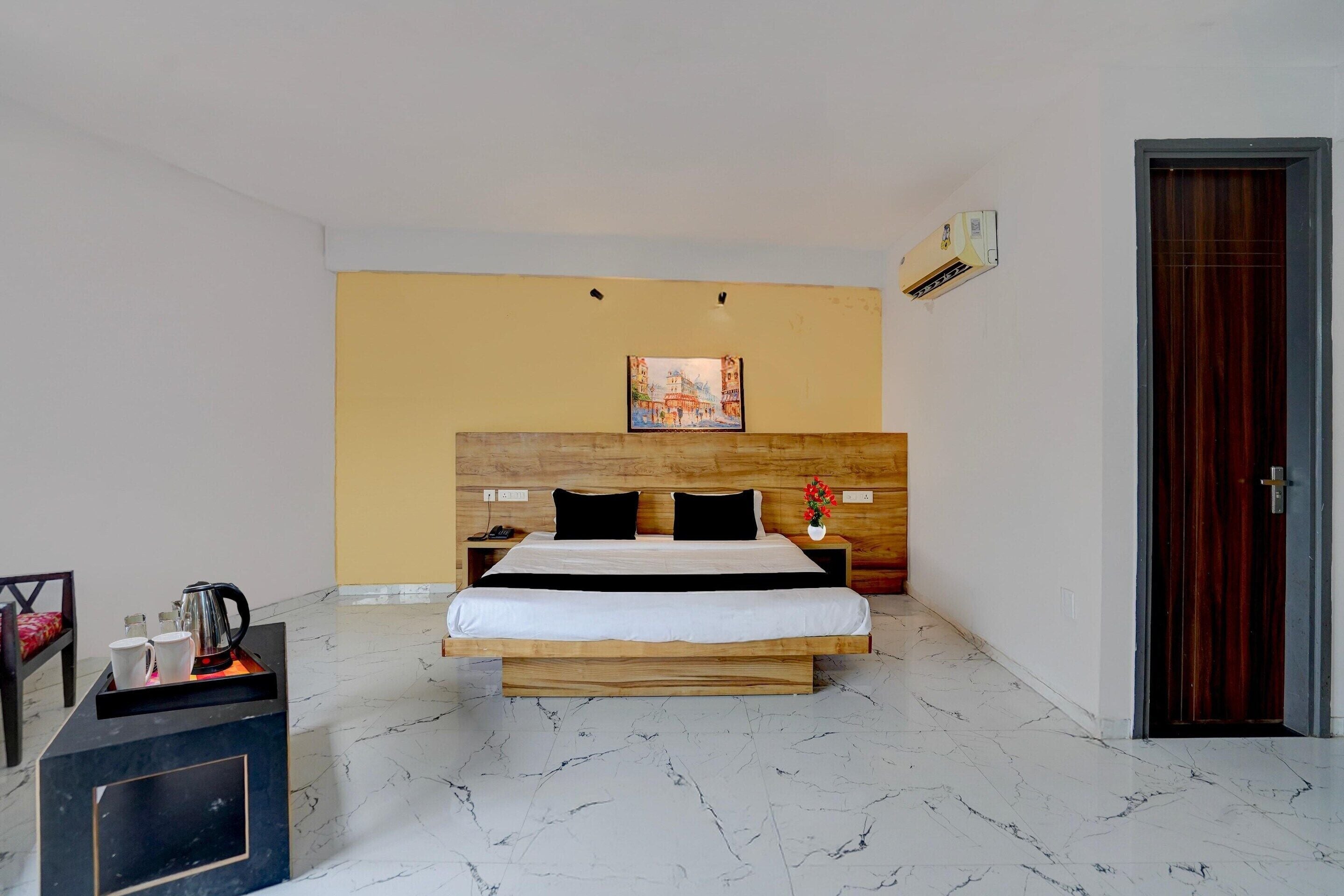 Une chambre d’hôtel avec un lit, une table de chevet et un tableau au mur.