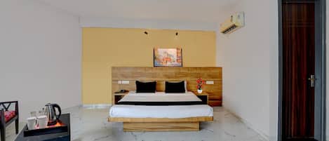Une chambre d’hôtel avec un lit, une table de chevet et un tableau au mur.