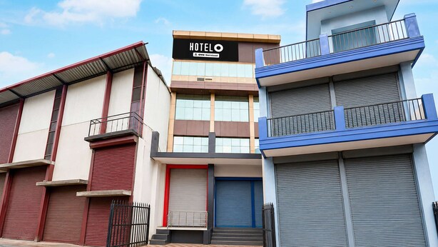 A hotel with a prominent sign, a gated entrance, and a checkered pavement. - Deluxe Room North Star Residency (Dehradun)