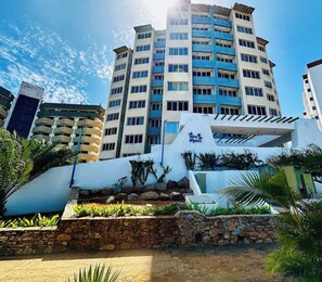 A multi-story hotel with a modern design, featuring a prominent entrance with a stone facade and a blue and white color scheme. - Margarita moderno Piscina, agua y parking (Porlamar)