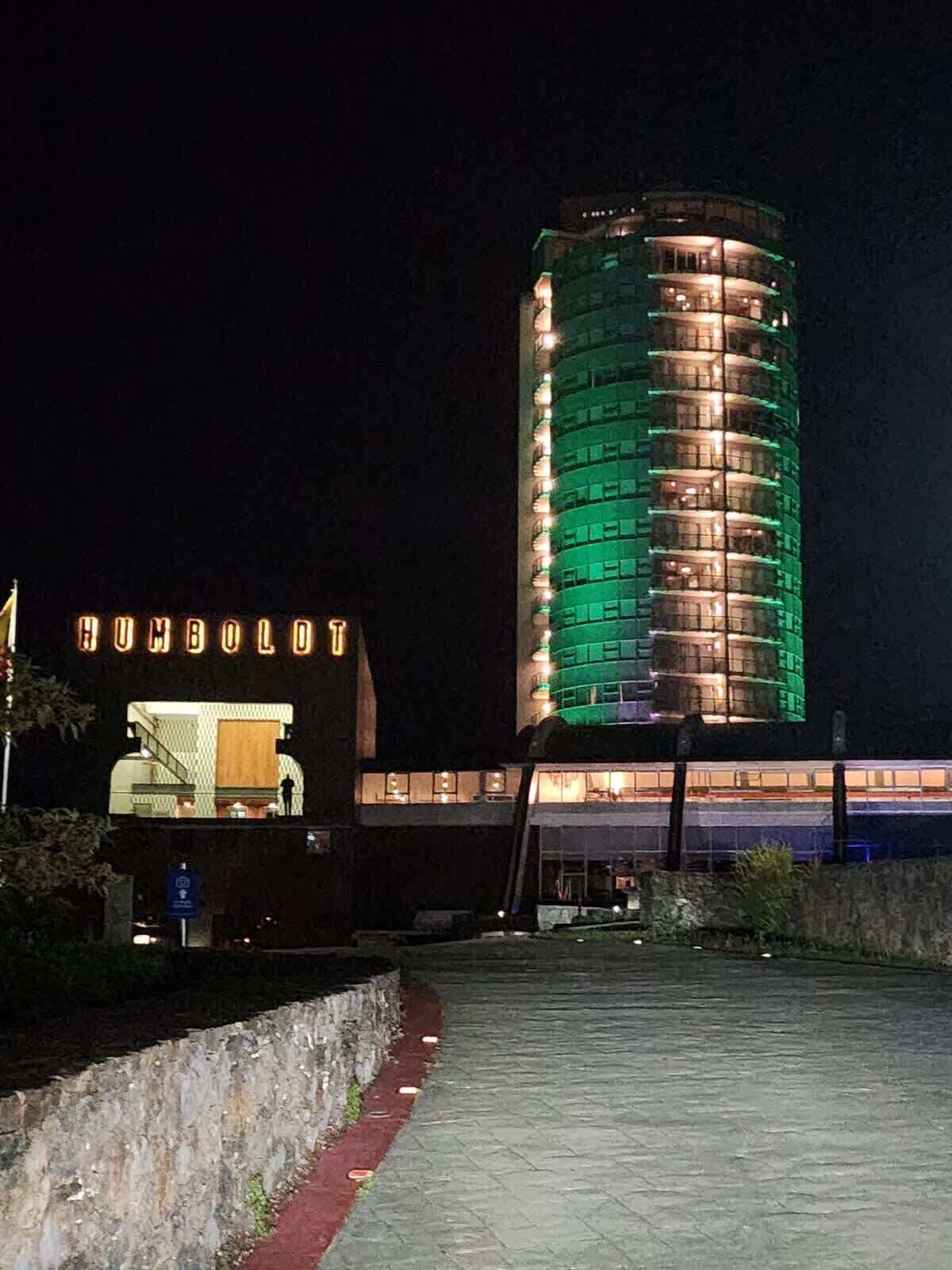 Ein Hotel mit einem markanten zylindrischen Turm, einem überdachten Außenbereich und einem Schild mit der Aufschrift 'HUMBOLDT'.