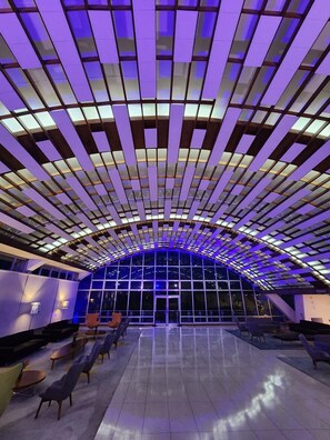 An interior space with a curved ceiling and a seating area with tables and chairs.