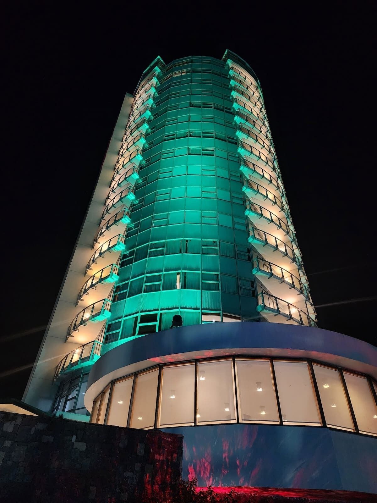 A multi-story hotel with a curved facade and balconies.