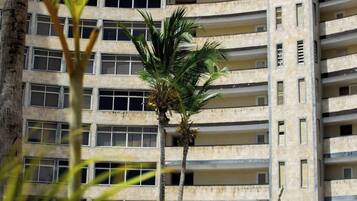 Un grattacielo con numerosi balconi e una piscina in primo piano.