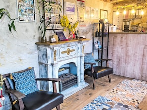 A cozy room with a fireplace, two chairs, a wooden floor, and a patterned rug. - Rubin Charme Häuser 10 D by Interhome (Porto)