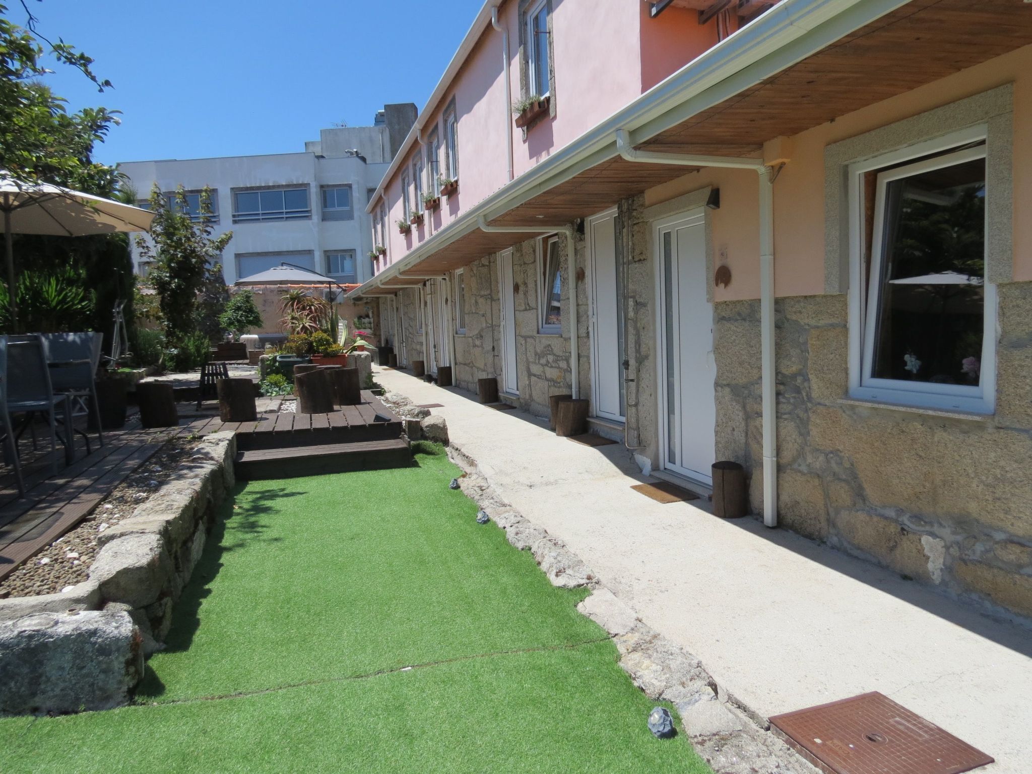 Une cour avec une pelouse artificielle, une petite piscine et du mobilier d’extérieur.
