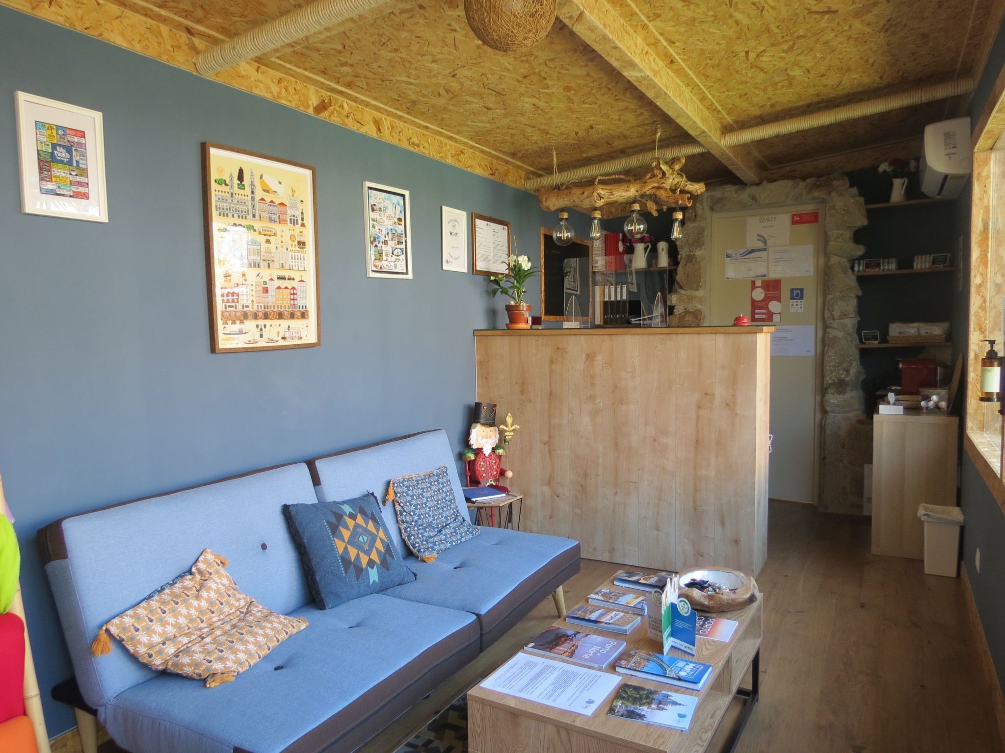 Een gezellige kamer met een blauwe bank, een houten bureau en een stenen muur.