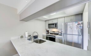 Eine moderne Küche mit einem Edelstahl-Kühlschrank, einer Mikrowelle und einem Backofen.