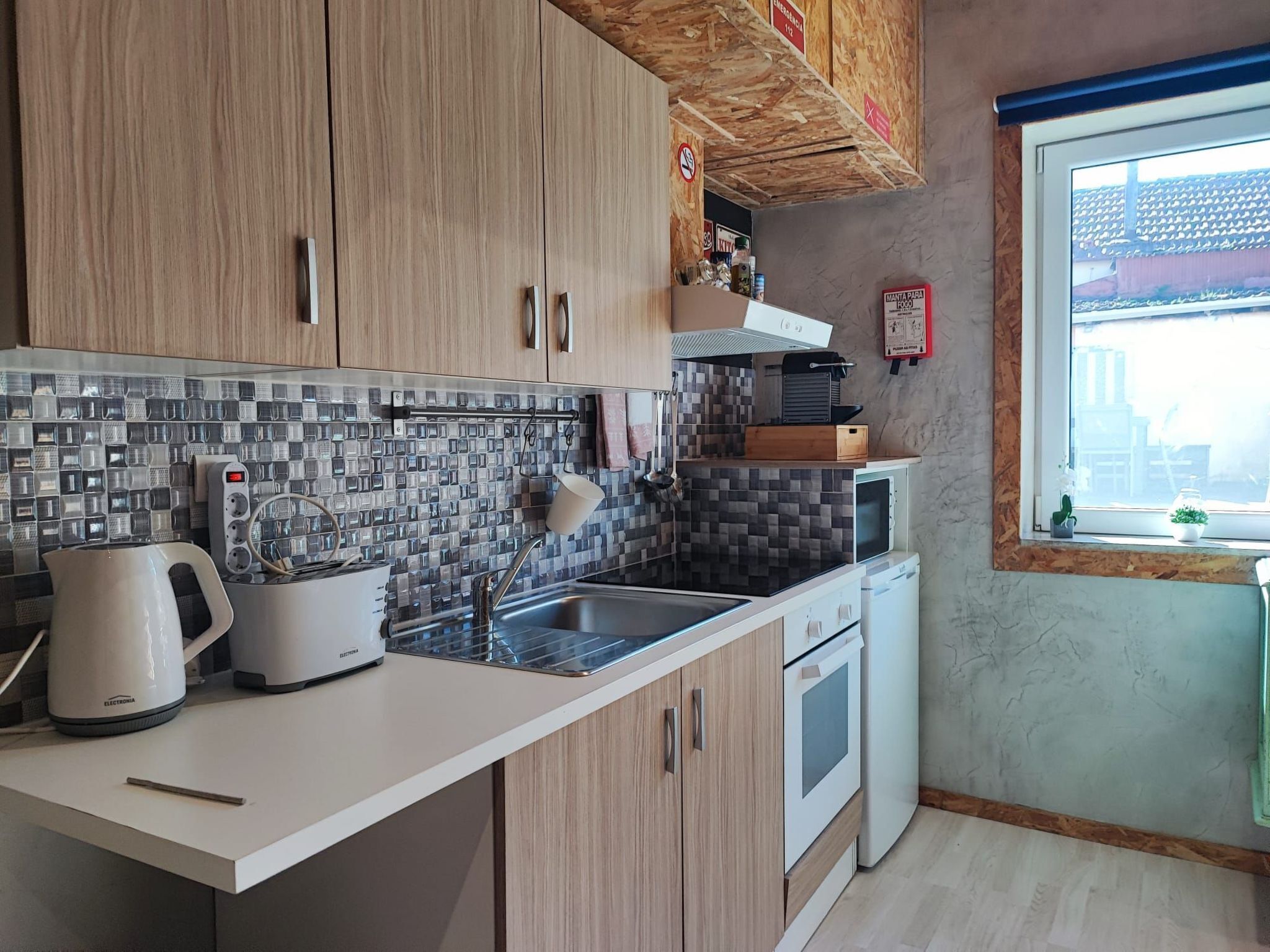 Une cuisine moderne avec des meubles en bois, un pare-feu en carrelage et une fenêtre offrant une belle vue.