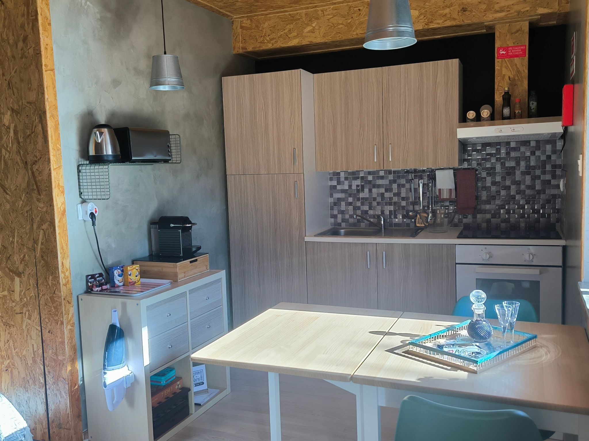 Une cuisine compacte avec des meubles en bois, un four à micro-ondes, un grille-pain et un petit réfrigérateur.