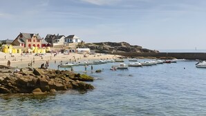 Uma cidade costeira com edifícios à beira-mar, águas cristalinas e barcos.