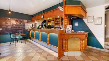 Un espace bar avec un comptoir en bois, des tabourets de bar bleus et une horloge murale.