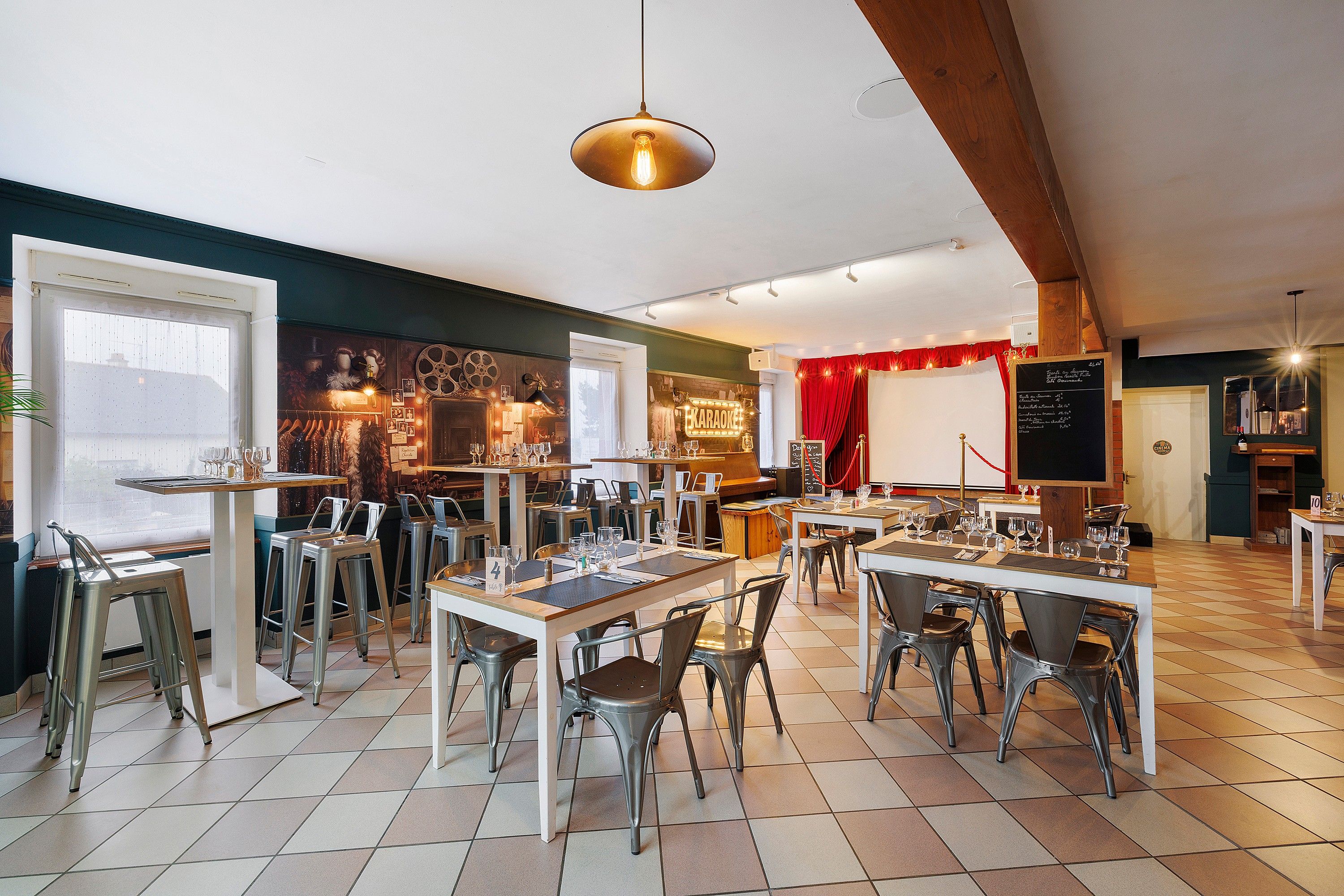 Un restaurante con varias mesas y sillas, una zona de bar y un escenario para espectáculos.
