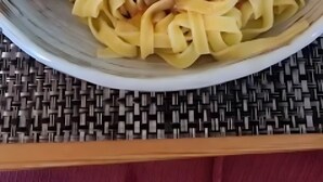 Un plato de pasta con carne y verduras.