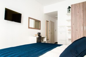 A bedroom with a bed, a desk, a chair, a TV, and a wardrobe. - Demi Rooms (Naples)
