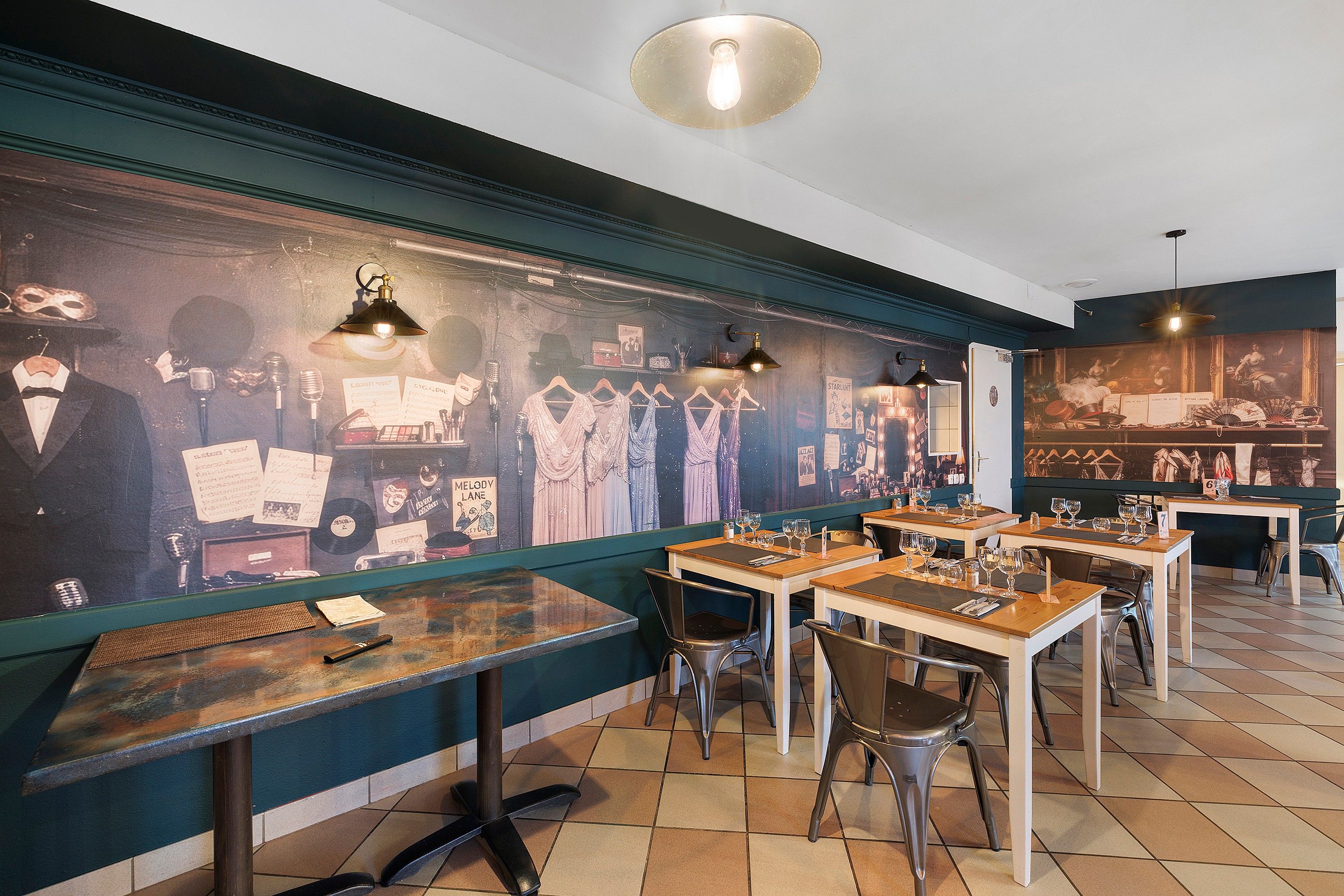 Een restaurantinterieur met houten tafels, stoelen en een muur met oude posters en kleding.