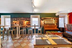 A restaurant with a bar area, tables set for dining, and a chalkboard menu.